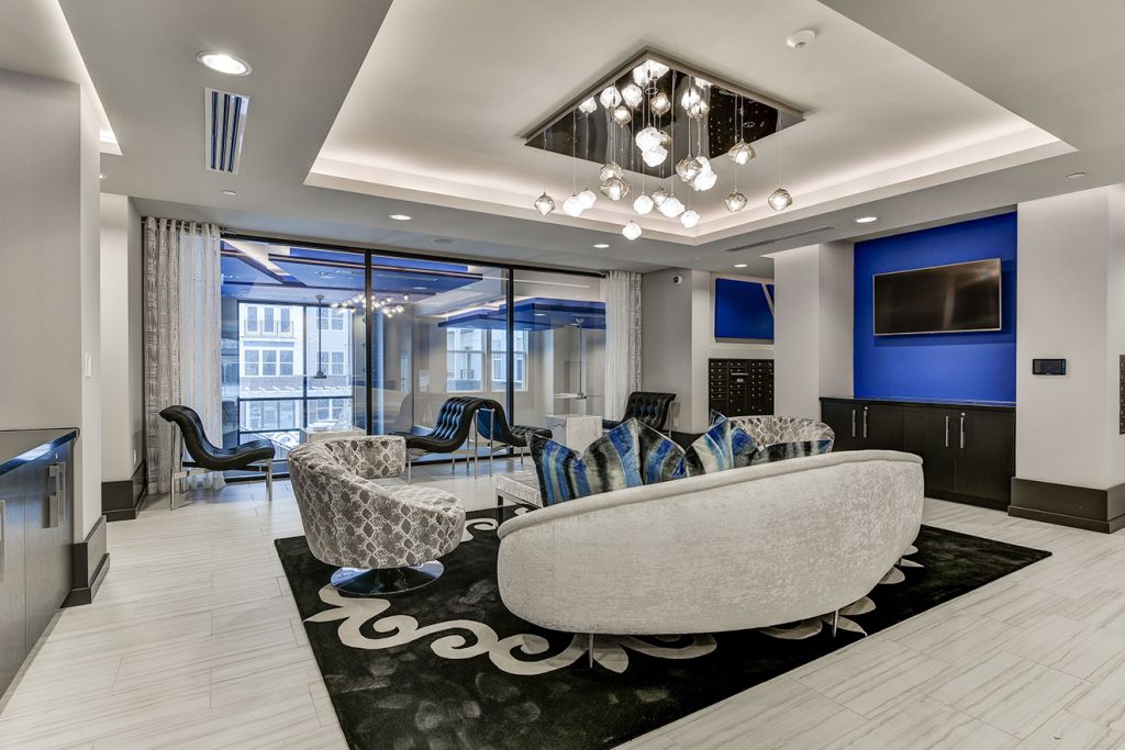 Alternate view of lounge area with contemporary accent furniture, wall-mounted TV, and espresso bar