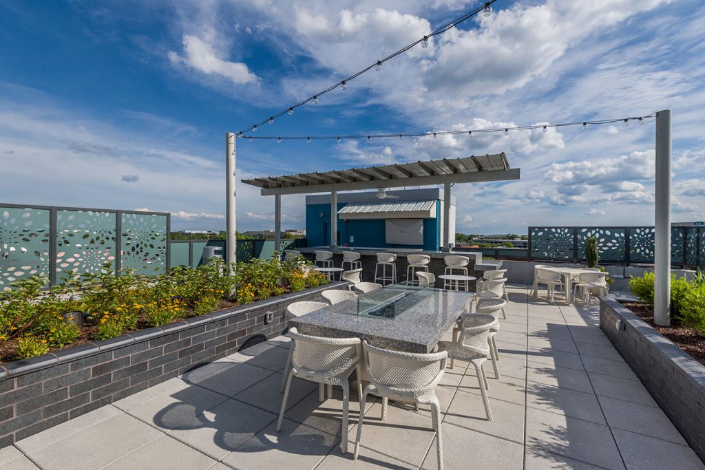 Rooftop lounge with outdoor dining and festival lighting