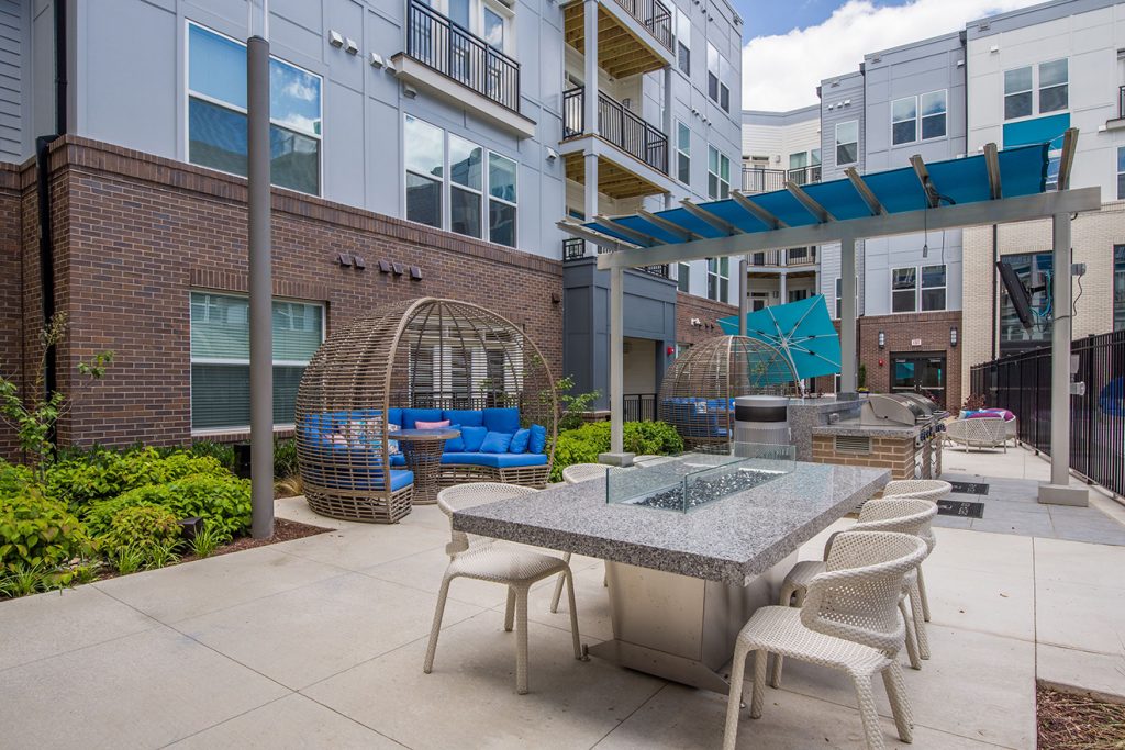 Community courtyard with outdoor kitchen, barbecue grills, and dining table