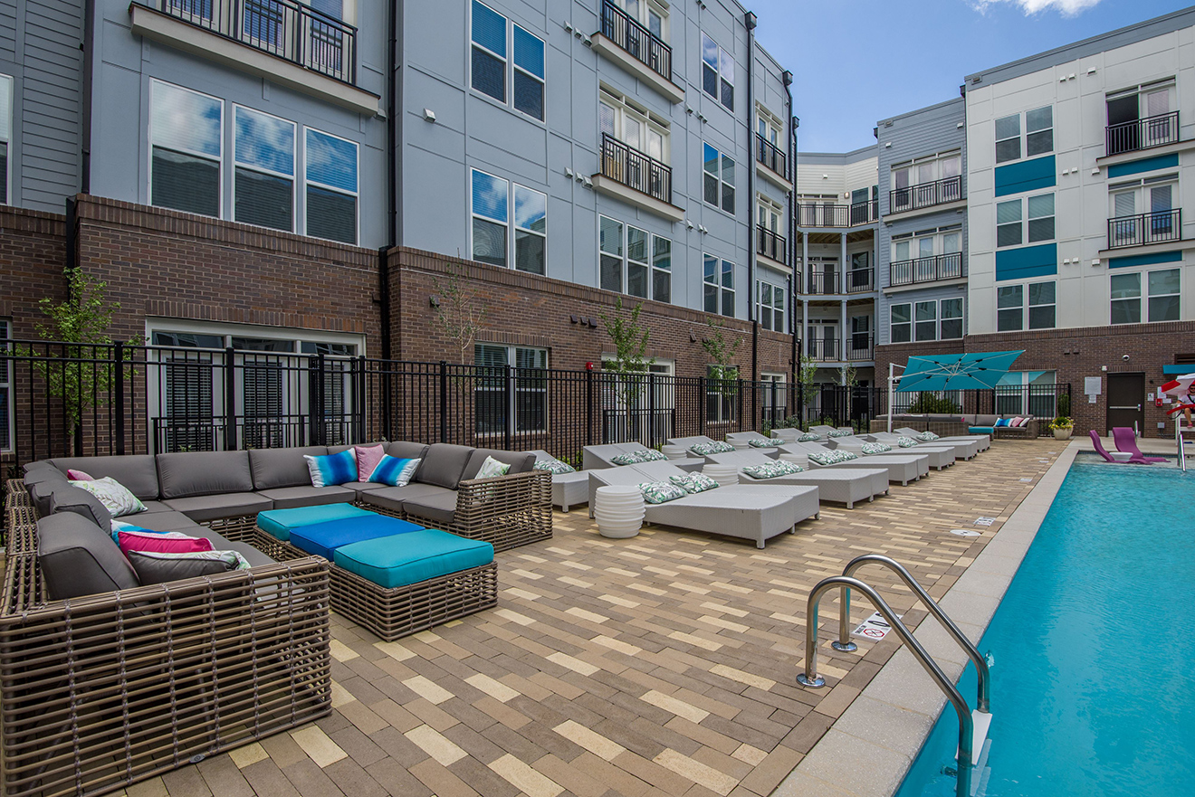 Swimming pool courtyard with lounge seating on deck as well as sectional sofas.