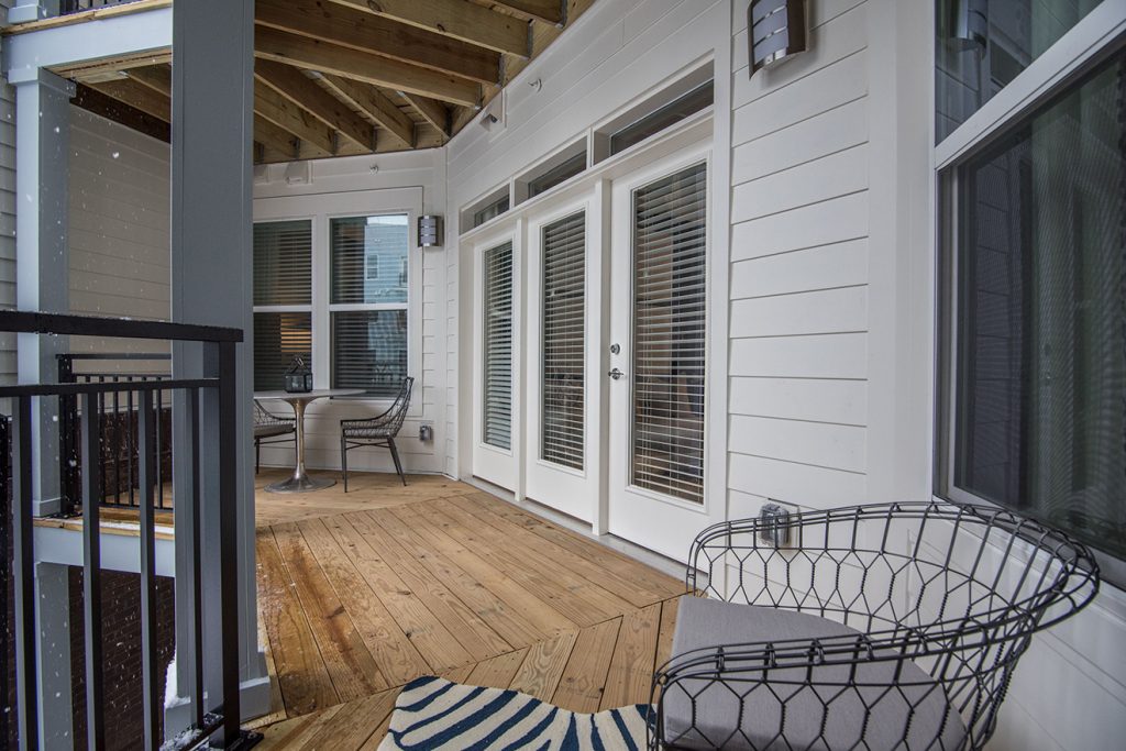 Alternative view of balcony and outdoor deck with rustic wood and bistro chairs