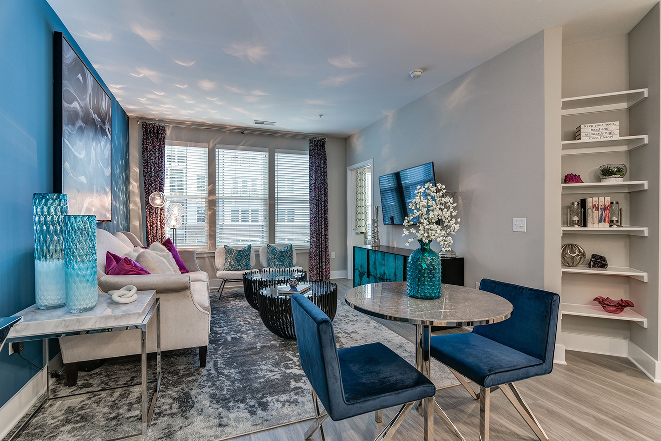 Model apartment living room with wall-mounted TV and built-in bookcases