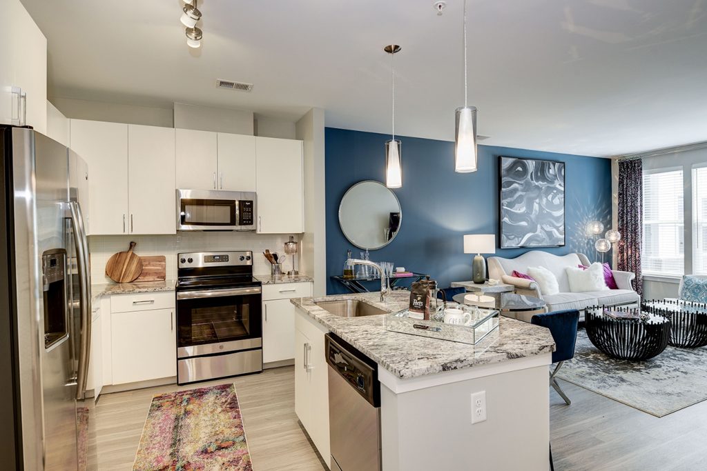 Model apartment with open-plan kitchen and living room with accent wall