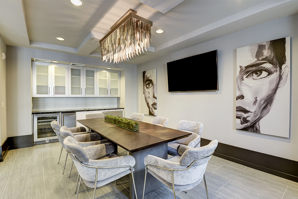 Conference room and meeting area with large wooden table, comfortable seating, cabinets, and mini fridge