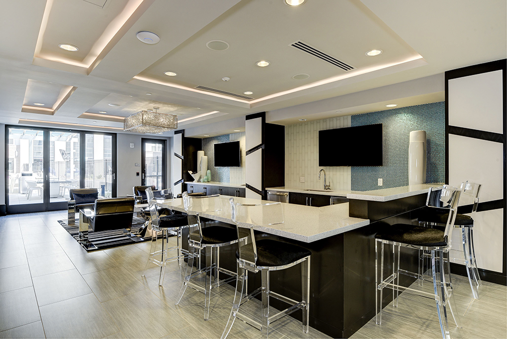 Demonstration kitchen with barstool seating and wall-mounted TV