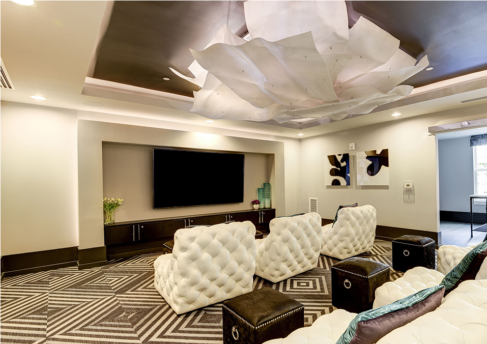 Community theater and media room with comfortable lounge chairs
